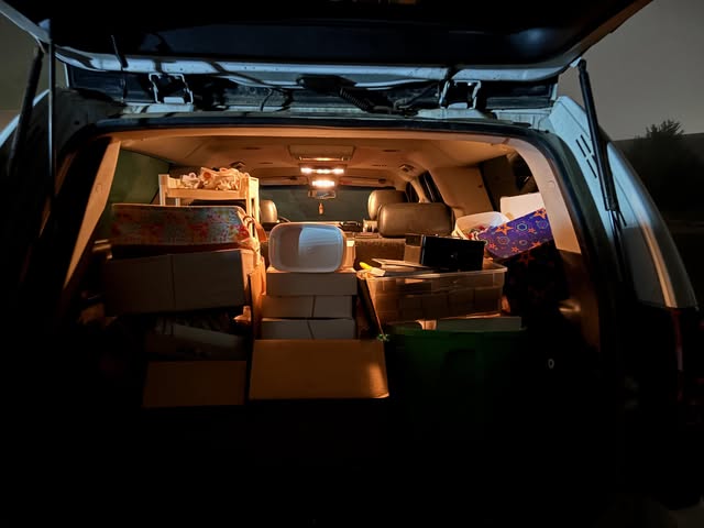 The back of a van packed full of boxes before sunrise.