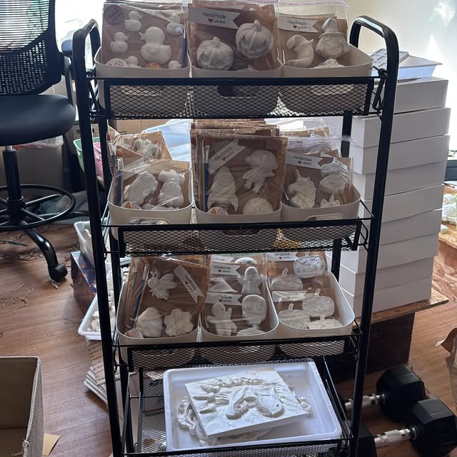 A rolling cart full of bagged kits: ducks, pumpkins, unicorns, gingerbread men, and ghosts.